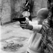 Palermo, 1982, vicino alla chiesa di Santa Chiara un bambino gioca a fare il killer con una calzamaglia in testa (il bambino è il figlio della giornalista di destra Marianna Bartocelli)